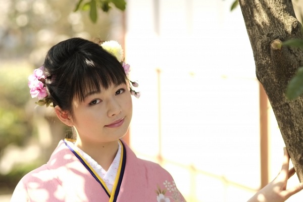 花の髪飾りとアップスタイルの前髪で振袖を着た女性の顔まわり
