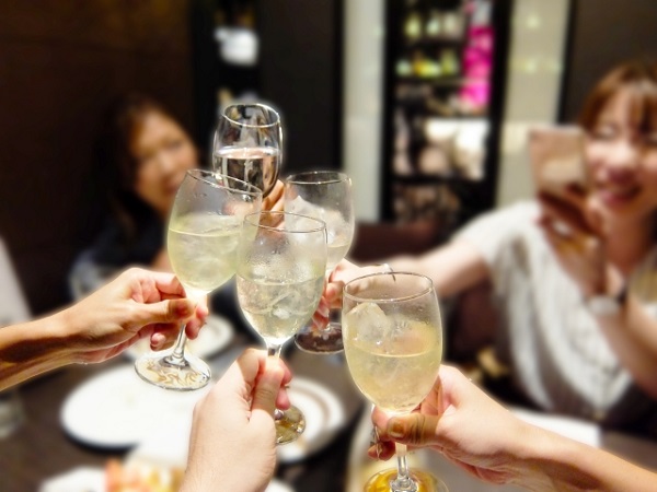 グラスを合わせて乾杯する成人式後の飲み会の様子