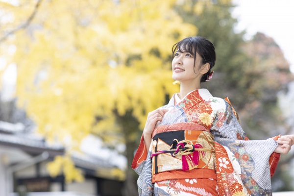 振袖を着て銀杏並木で微笑む新成人の女性